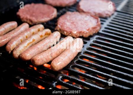 Hamburger auf Grill mit tanzenden Flammen, perfekt zubereitet Stockfoto