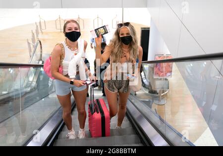 Die Freunde Poppy (links) und Shannon, beide 20 Jahre alt und aus Glasgow, fahren nach dem Check-in für ihren Flug nach Ibiza zum Abflugsteig am Flughafen Glasgow. Bilddatum: Montag, 19. Juli 2021. Stockfoto