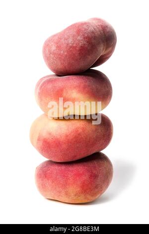 Haufen von ganzen flachen Pfirsichen übereinander gestapelt isoliert auf weißem Hintergrund. Als Designelement. Stockfoto