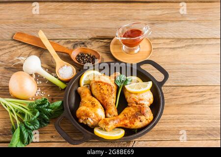 Gebratene Hähnchenschenkel in einer Pfanne mit Gemüsesalat und Ketchup. Stockfoto