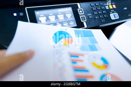 Büromitarbeiter drucken Papier auf einem Multifunktions-Laserdrucker. Kopier-, Druck-, Scan- und Faxgerät im Büro. Moderne Drucktechnologie. Kopiergerät. Stockfoto