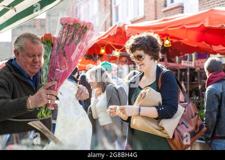 LONDON, ENGLAND - Oktober 12, 2018 Menschen Blumen kaufen an der Columbia Road Blumenmarkt. Diese Londoner principal Blumenmarkt ist jeden Sonntag geöffnet. Stockfoto