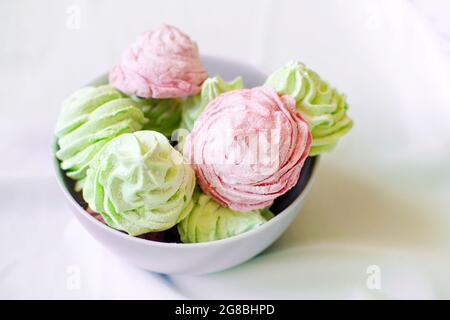 Köstliche hausgemachte Minze und Himbeer-Sumpfmarmelibe in einer grauen Schüssel auf dem Tisch. Natürliche gesunde Süßigkeiten. Stockfoto