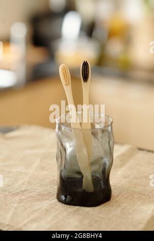 Zwei biologisch abbaubare Bambus-Zahnbürsten aus schwarzem Glas Stockfoto