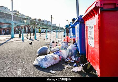 Brighton UK 19. Juli 2021 - überströmte Mülleimer, als Müll am Strand und am Strand von Brighton zurückgelassen wurde, nachdem am Wochenende bei heißem Wetter Menschenmassen an die Küste strömten. Die Angestellten des Rats waren ab 5 Uhr morgens draußen, um den Strand und das Meer zu säubern: Credit Simon Dack / Alamy Live News Stockfoto