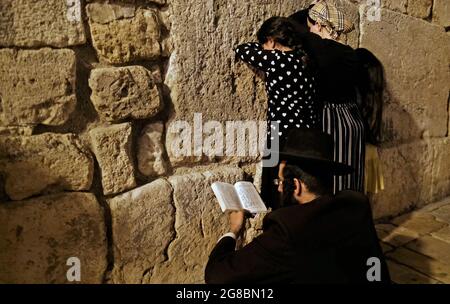 Religiöse Juden trauern in der Kleinen Westmauer, auch bekannt als HaKotel HaKatan oder das kleine Kotel, das eine jüdische religiöse Stätte im muslimischen Viertel ist, am jüdischen Fest der Tisha B'AV am 18. Juli 2021 in Jerusalem, Israel. In der Nacht des 17. Juli versammelten sich Juden auf der ganzen Welt, um aus dem Buch der Klagelieder zu lesen und damit den Beginn des Tisha B'AV, des jährlichen Fastentages zum Gedenken an die Zerstörung des ersten und zweiten Tempels in Jerusalem, zu begehen. Stockfoto