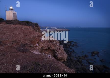 Leuchtturm von Conil am Abend vom Meer umgeben in Carz, Spanien Stockfoto