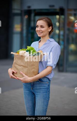 Frau mit Essen in der Tasche auf Supermarkt Parkplatz Stockfoto