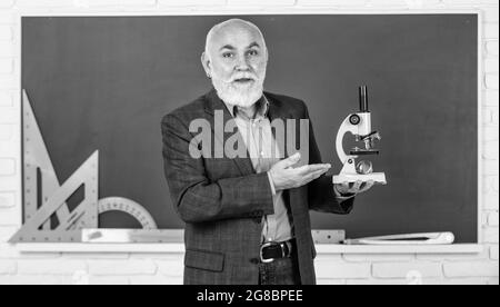 Entdecken Heilung. Wissenschaft Experimente im Labor. Biologie Schule Laborausrüstung. Mann im Klassenzimmer mit mathematischen Werkzeugen an der Tafel. Senior Lehrer verwenden Stockfoto