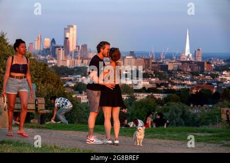 Bei heißem Wetter Hampstead Heath mit Picknickern, die den Sonnenuntergang über der Londoner Skyline genießen. Bild von Gavin Rodgers/ Pixel8000 Stockfoto