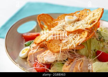 Caesar-Salat mit gegrilltem Hähnchen auf weißem Holzhintergrund Stockfoto
