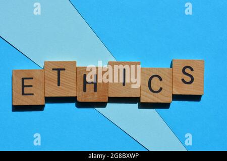 Ethik, Wort in hölzernen Buchstaben auf blauem Hintergrund isoliert Stockfoto