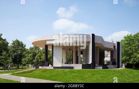 Seitenansicht des Pavillons, dahinter Serpentine Gallery. Serpentine Pavilion 2021, London, Vereinigtes Königreich. Architekt: Counterspace, 2021. Stockfoto