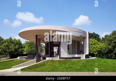 Seitenansicht des Pavillons, dahinter Serpentine Gallery. Serpentine Pavilion 2021, London, Vereinigtes Königreich. Architekt: Counterspace, 2021. Stockfoto