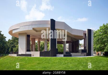 Seitenansicht des Pavillons, dahinter Serpentine Gallery. Serpentine Pavilion 2021, London, Vereinigtes Königreich. Architekt: Counterspace, 2021. Stockfoto