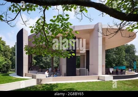 Seitenansicht des Pavilloneingangs mit Baumzweig. Serpentine Pavilion 2021, London, Vereinigtes Königreich. Architekt: Counterspace, 2021. Stockfoto