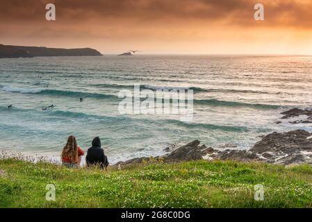 Die Menschen genießen am Ende des Tages in Newquay in Cornwall den Blick über die Bucht von Fistral. Stockfoto