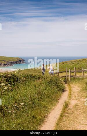 Ein Fußweg, der durch Felder zu einem hölzernen Tor führt und hinunter zum Polly Porth Joke in Newquay in Cornwall führt. Stockfoto