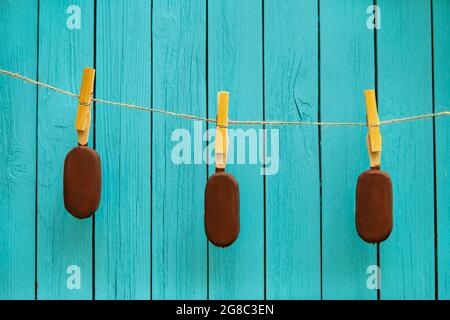 Drei leckere Schokoladeneis auf Seil in der Nähe türkisfarbenen Hintergrund. Sommer Food-Konzept Stockfoto