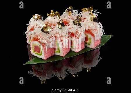 Sushi-Rollen mit Lachs und Thunfisch in Mamenori mit Daikon, Tobiko und essbarem Gold Stockfoto