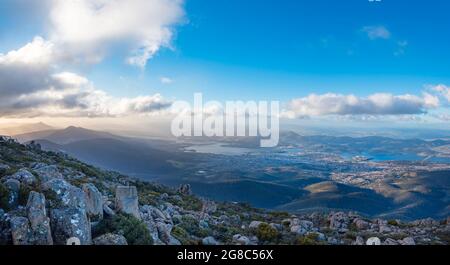 Ein Panoramablick vom Mount Wellington am späten Nachmittag, während Wolken über Hobart, der Hauptstadt Tasmaniens und dem Derwent River in Australien, Rollen Stockfoto