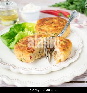 Fischschnitzel, zubereitet aus Thunfisch und Kartoffeln, mit Zusatz von Chilli, grüner Petersilie und Schnittlauch. Stockfoto