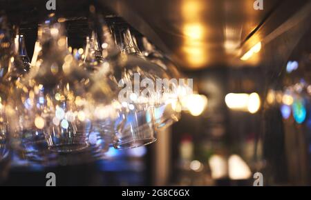 Details von Wein- oder Biergläsern hängen an einer Restaurantbar Stockfoto