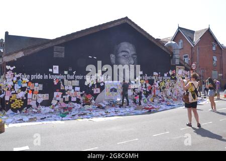 Manchester, Vereinigtes Königreich, 19. Juli 2021 der Stadtrat von Manchester wird dafür sorgen, dass am Marcus Rashford Wandgemälde in der Moorfield Street, Withington, Manchester, England, Vereinigtes Königreich, erhalten bleiben. Mitarbeiter der Gallerien-Abteilung des Rates halten die Ehrungen aufrecht. Auf dem riesigen MBE-Wandgemälde des Manchester United-Spielers Marcus Rashford, das nach dem Fußballverlust der Euro2020 am 11. Juli 2021 durch missbräuchliche Graffiti verwüstet wurde, haben Menschen Tausende unterstützende Notizen, Bilder, Fahnen, Blumen und antirassistische Botschaften hinterlassen. Quelle: Terry Waller/Alamy Live News Stockfoto