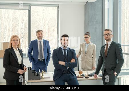 Porträt einer Gruppe von Geschäftsleuten, die beim Arbeiten im Team im Büro auf die Kamera schauen Stockfoto