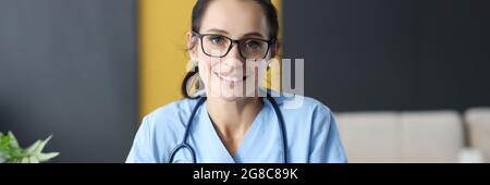 Ärztin mit Brille, die Krankengeschichte ausfüllt Stockfoto