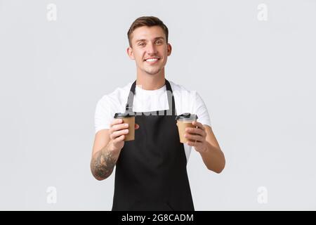 Konzept für kleine Unternehmen, Café, Café und Restaurants. Ein schöner, charismatischer Barista, der Kellner gab Kaffee zum Mitnehmen in Pappbechern, bereitete eine Bestellung vor Stockfoto