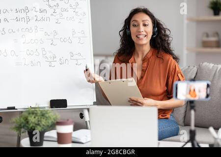 Weibliche Lehrerin im Headset erklärt den Schülern online trigonometrische Funktionen Stockfoto