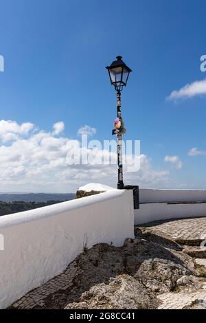 Nazare, Portugal - 28. Juni 2021: Straßenlaterne mit Aufklebern auf dem Geländer des Miroudouro do Suberco Stockfoto