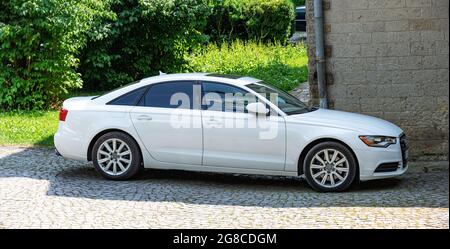 Der weiße Audi A6 C7 steht in der Nähe des Gebäudes. Stockfoto