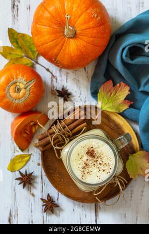 Herbstgetränk. Kürbis gewürzter Latte oder Kaffee im Glas auf einem rustikalen Holztisch. Draufsicht flach lay Hintergrund. Stockfoto