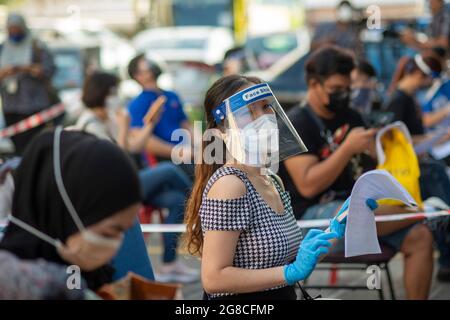 Kuala Lumpur, Malaysia. Juli 2021. In Kuala Lumpur, Malaysia, 19. Juli 2021, warten Menschen mit Gesichtsmasken darauf, COVID-19-Impfstoffe zu erhalten. Malaysia meldete weitere 10,972 neue COVID-19-Infektionen, teilte das Gesundheitsministerium am Montag mit, was die landesweite Gesamtzahl auf 927,533 beläuft. Quelle: Chong Voon Chung/Xinhua/Alamy Live News Stockfoto