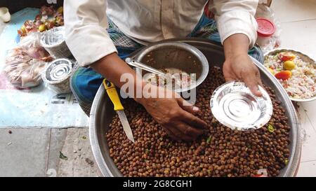 Straßenhändler, der in Indien verschiedene Obst- und Gemüsesorten serviert Stockfoto