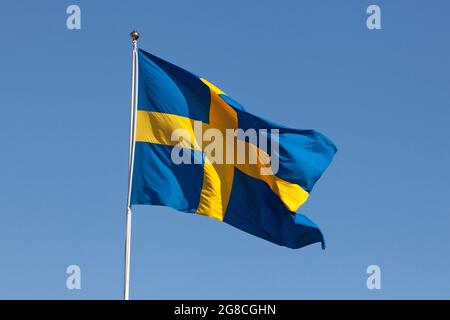 Stockholm, Schweden - 29. Mai 2021: Eine schwedische Flagge, die während eines Fahnentages im Wind als nationales Symbol Schwedens winkt. Stockfoto