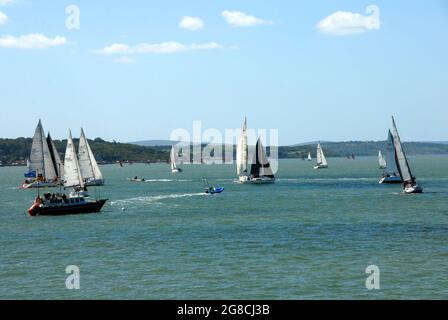 Yachten, die auf der Solent während der Cowes Week Regatta mit anderen kleinen Booten in der Nähe segeln Stockfoto