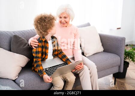 Großeltern und Enkel spielen zu Hause - Familie zu Hause, Großmutter kümmert sich um Neffen Stockfoto