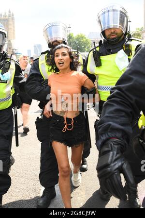 Eine Frau wird von der Polizei weggeführt, als Anti-Impfdemonstranten auf dem Parliament Square in London eine Demonstration abhalten, nachdem die endgültigen rechtlichen Beschränkungen in England aufgehoben wurden. Bilddatum: Montag, 19. Juli 2021. Stockfoto