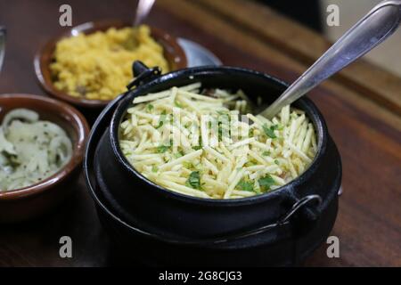 Biro-Biro. Brasilianische Reisgerichte im Grill. Mit Kartoffeln und Speck. Schöne Töpfe und Hintergrund.. Stockfoto