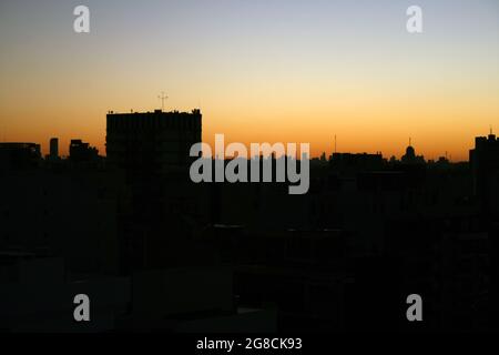 Die Gebäude mit der orangefarbenen Sonne dahinter, Hintergrundbeleuchtung Stockfoto