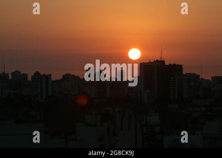 Die Gebäude mit der orangefarbenen Sonne dahinter, Hintergrundbeleuchtung Stockfoto