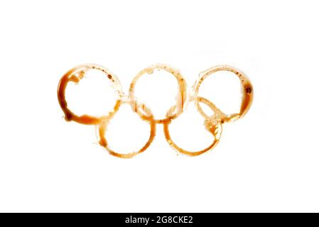 Olympische Ringe aus Kaffeeflecken auf weißem Hintergrund isoliert Stockfoto