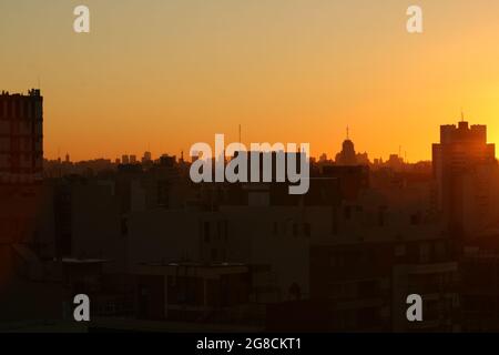 Die Gebäude mit der orangefarbenen Sonne dahinter, Hintergrundbeleuchtung Stockfoto