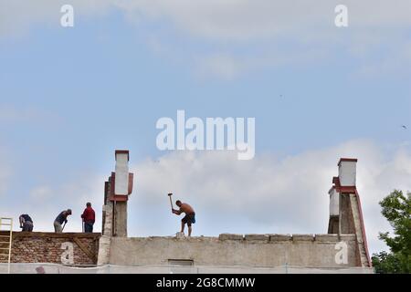 Männer bei der Renovierung des Daches des Gebäudes. Sommer. Stockfoto