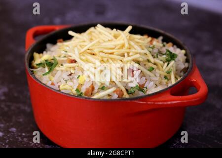 Biro-Biro. Brasilianische Reisgerichte im Grill. Mit Kartoffeln und Speck. Schöne Töpfe und Hintergrund. Draufsicht. Stockfoto