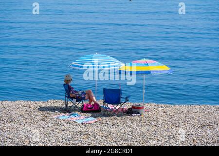 Bier, East Devon; 19. Juli 2021. Wetter in Großbritannien: Urlauber genießen den herrlichen Sonnenschein und entspannen sich am Strand und kühlen sich im blauen Meer im hübschen Fischer- und Küstendorf Beer, East Devon ab. Kredit: Celia McMahon/Alamy Live Nachrichten Stockfoto