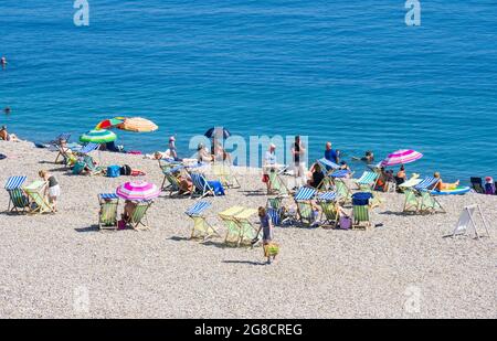 Bier, East Devon; 19. Juli 2021. Wetter in Großbritannien: Urlauber genießen den herrlichen Sonnenschein und entspannen sich am Strand und kühlen sich im blauen Meer im hübschen Fischer- und Küstendorf Beer, East Devon ab. Kredit: Celia McMahon/Alamy Live Nachrichten Stockfoto